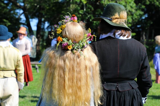 Pilgrim bride and groom watch wedding guests celebrate.