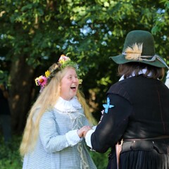 Pilgrim bride holds the groom's hands and smiles widley as they are married.