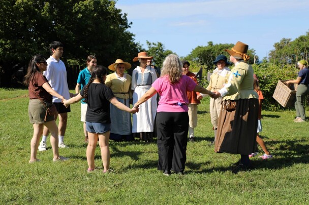 Guests and Pilgrims join hands in a circle.