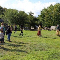 Guests watch three Pilgrim women as they entertain visitors with musical instruments.