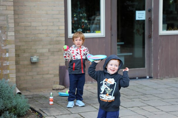 Two children play catch outside of the Museum's Craft Center.