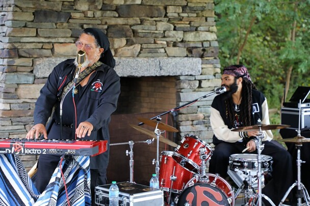 The Groovalottos lead singer and drummer both sing into microphones.