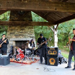 The lead singer, drummer, guitarist, and saxophone player of The GroovaLottos perform at Plimoth Patuxet Museums.