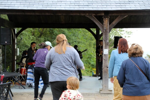 A group of women and children dance to live music.