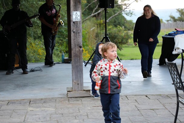 A mother follows her young child who is running after another young child to play.