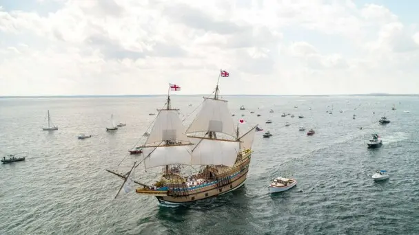Mayflower ii under sail with several boats around her