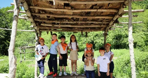 Multiple school children under outdoor arbor on Historic Patuxet Homesite