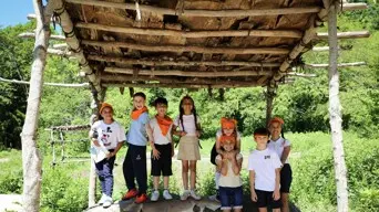 Multiple school children under outdoor arbor on Historic Patuxet Homesite