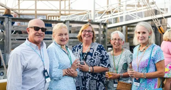 Group of four woman and one man posed on dock