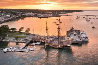 Ariel view of Mayflower II docked in downtown Plymouth at sunset