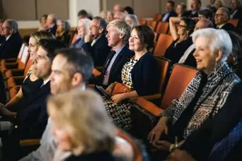 Crowd seated in a movie theater looking towards the screen