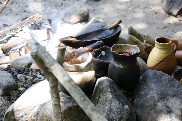 Wampanoag cooking pot set over a fire outdoors