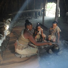 A woman serves two children nasaump in a wetu