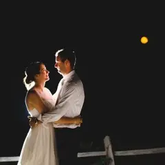 Bride and groom embrace under a full moon