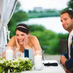 Wedding couple seated before a table arrangement laugh