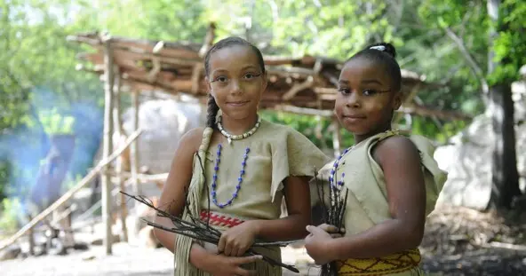Two young Wampanoag girls on the Historic Patuxet Homesite wearing Wampanoag regalia