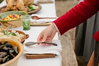Pilgrim woman sets table for a Harvest Feast