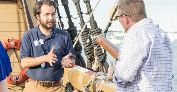 Mayflower II crew member in conversation with guest aboard the ship.