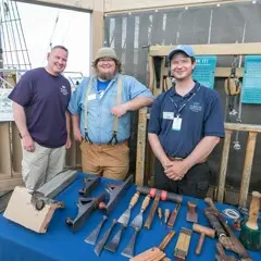 Mayflower II crew poses with guest on exhibit dock.
